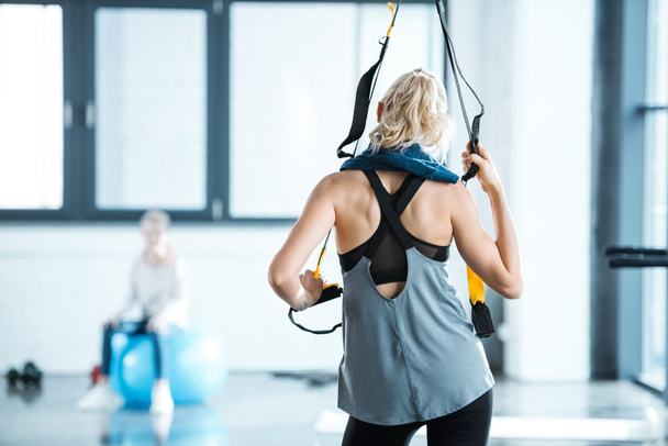 Γυναίκα Ξανθιά Γυμναστήριο προπόνηση με ιμάντες trx γυμναστήριο - Φωτογραφία, εικόνα
