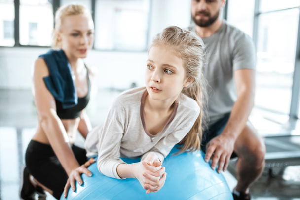 Cute gir exercising on swiss ball with parents - Photo, Image