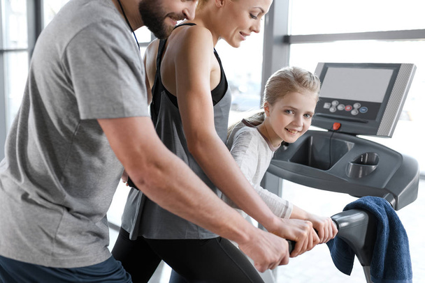 Happy family workout on treadmill, side view  - Foto, afbeelding