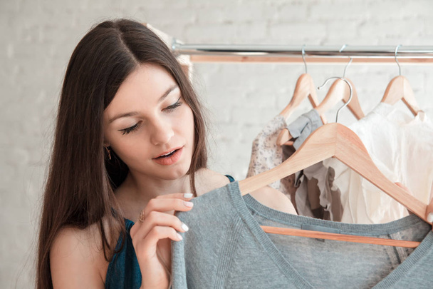 Woman looking at clothes hangs - Photo, Image