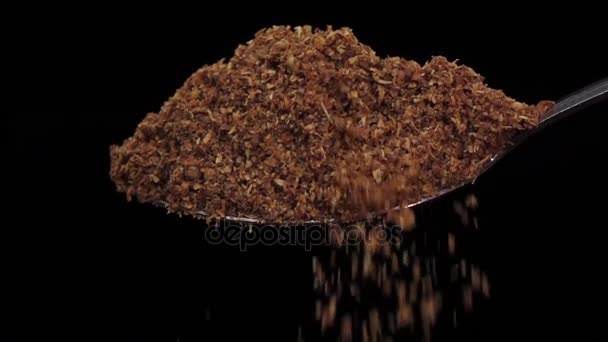 Crushed turmeric falling from the iron spoon, black background studio, slow motion - Footage, Video