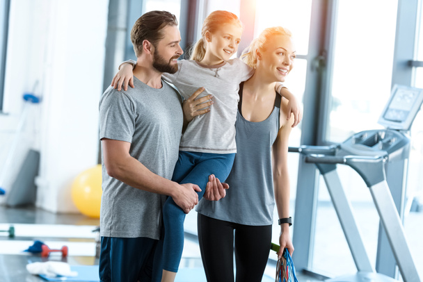 Portrait of happy family standing together at fitness center - Photo, Image