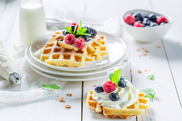Closeup of tasty waffles with berry fruits and whipped cream - Photo, image
