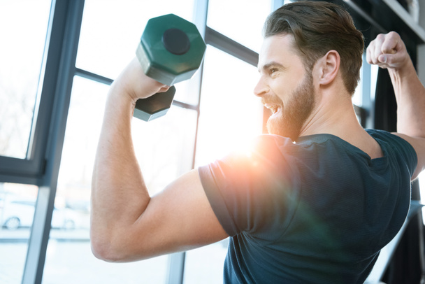 Handsome young guy workout with dumbbell - Photo, Image