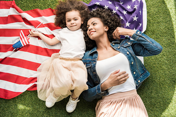 woman with daughter on american flag - Foto, afbeelding