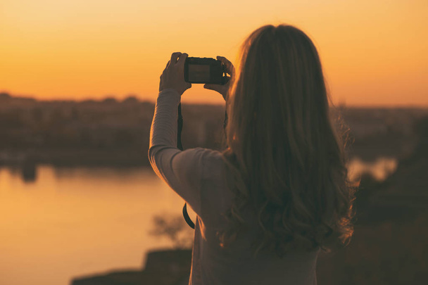 Woman photographing sunset - Foto, immagini