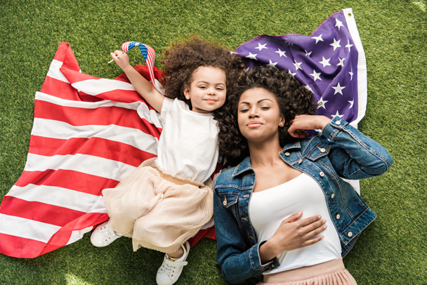 woman with daughter on american flag - Фото, изображение
