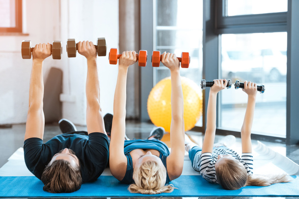 Exercice familial heureux avec haltères à la salle de fitness
 - Photo, image