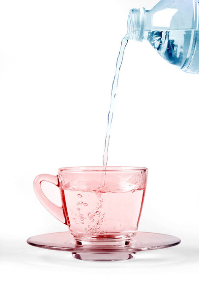 verter agua en un vaso de una botella, sobre fondo blanco
 - Foto, Imagen