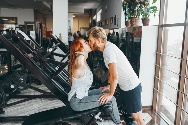 Erkek, kız arkadaşını spor salonunda öpüyor. - Fotoğraf, Görsel