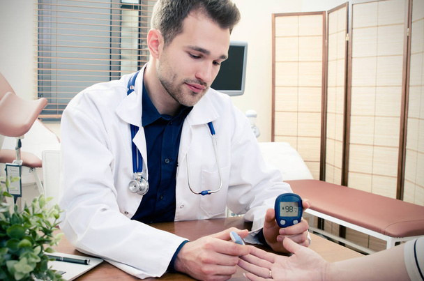 Doctor measuring of blood sugar for diabetes patient. - Photo, image