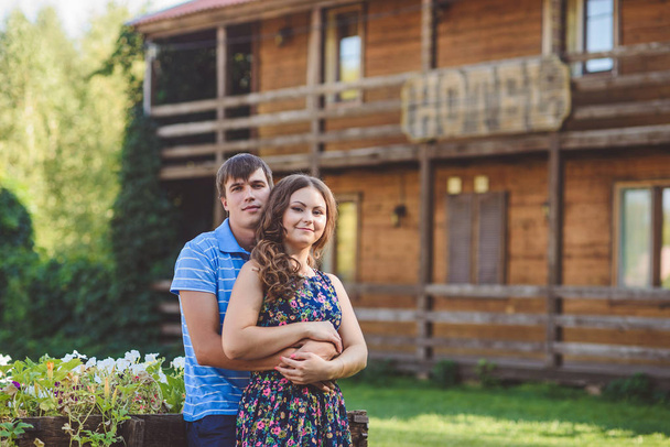 Romantic young couple hugging each other on the background of the hotel in a rustic style. - Photo, Image