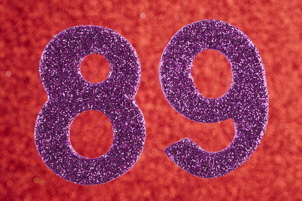 Número oitenta e nove cor roxa sobre um fundo vermelho. Anniversa
 - Foto, Imagem