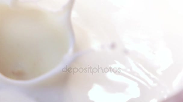 Two videos of pieces of orange falling into yogurt in real slow motion - 映像、動画