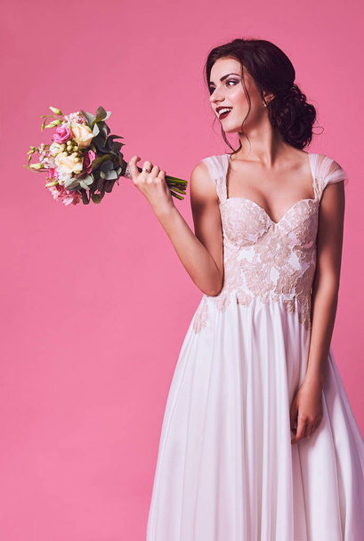 Brunet bride portrait in pink studio - Foto, afbeelding