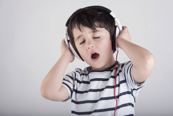 Child with headphones, listening to music - Fotó, kép