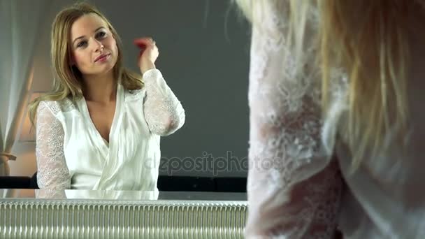 vrouw past haar haar voor een spiegel - Video