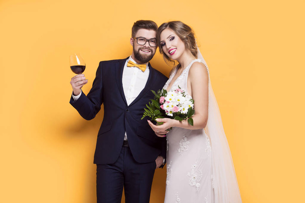 Smiling young newly married on a yellow background - Фото, изображение