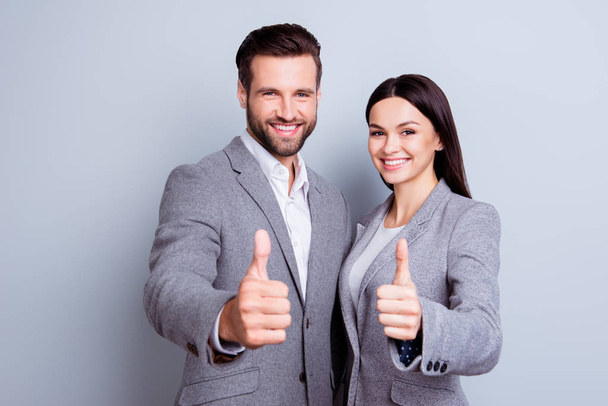 Two confident smiling businesspeople in formalwear showing thumb - Foto, Imagen