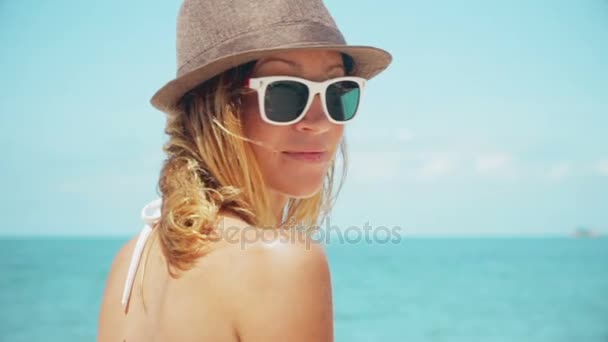Beautiful woman on beach looking back at camera smiling slow motion - Video, Çekim
