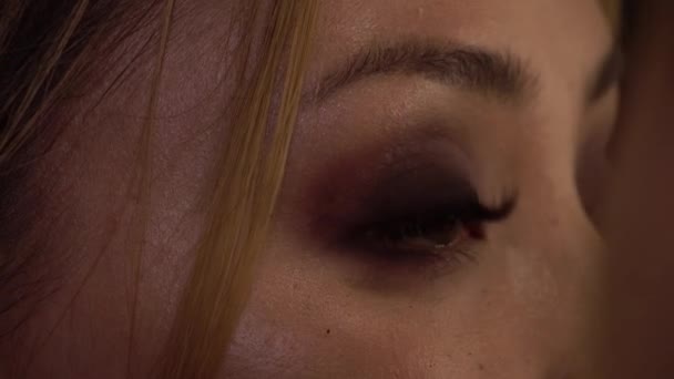 Detail of a young woman applying makeup with brush. Close up. Beauty shop. - Video, Çekim