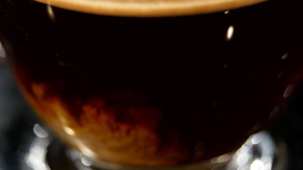 Milk pouring into coffee in a glass in slow motion - Foto, immagini