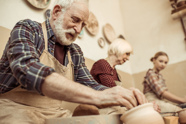 Grandmother and grandfather with granddaughter making pottery at workshop - Zdjęcie, obraz