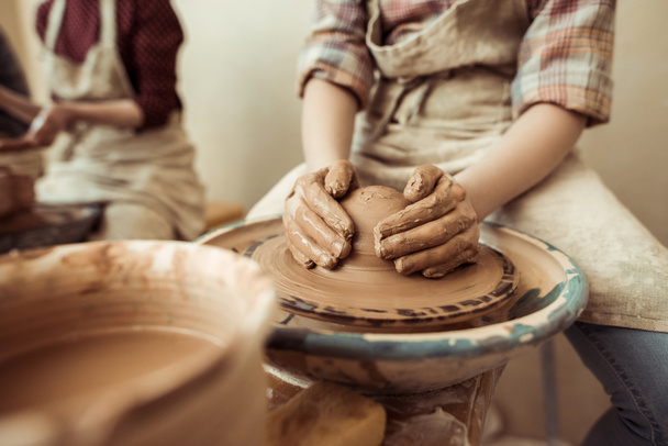 Close up of child hands working on pottery wheel at workshop - Fotografie, Obrázek