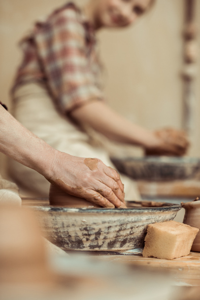 Close up van vrouwelijke handen werken op potters wiel - Foto, afbeelding