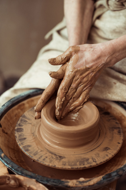 Close up of female hands working on potters wheel - Foto, afbeelding