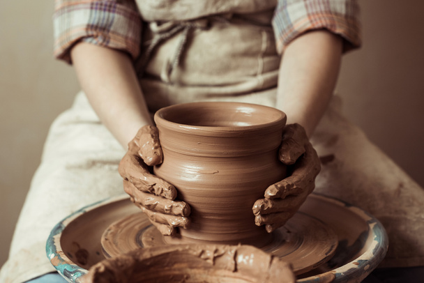 Gros plan des mains d'enfants travaillant sur la roue de poterie à l'atelier
 - Photo, image