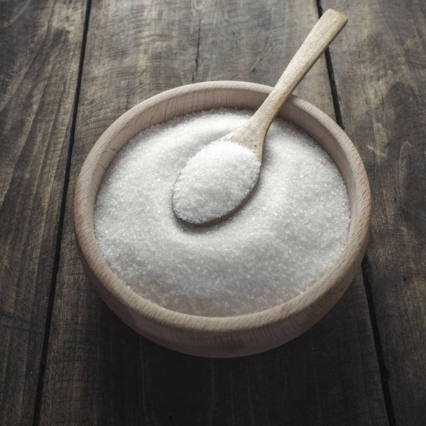 White sugar with spoon in wooden bowl - Фото, изображение