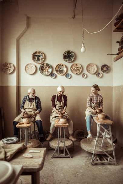Oma en opa met kleindochter maken van aardewerk op workshop - Foto, afbeelding