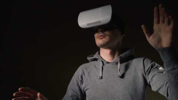 Mies yllään virtuaalitodellisuus kuulokkeet olohuoneessa
. - Materiaali, video