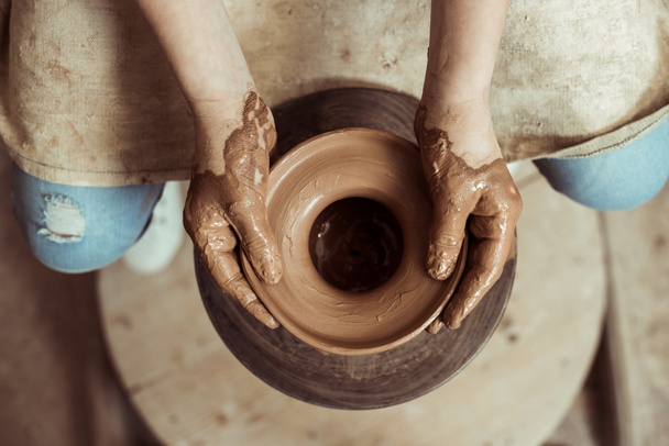 Primer plano de las manos de los niños que trabajan en la rueda de cerámica en el taller
 - Foto, imagen