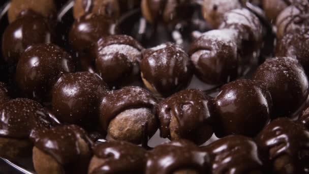 En cámara lenta. Trufas cubiertas de chocolate, caramelos, espolvorear con azúcar en polvo
 - Metraje, vídeo