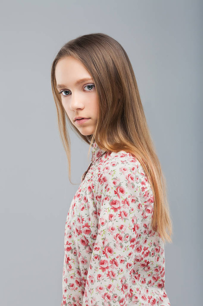 pretty young girl standing in studio and looking at camera - Фото, изображение