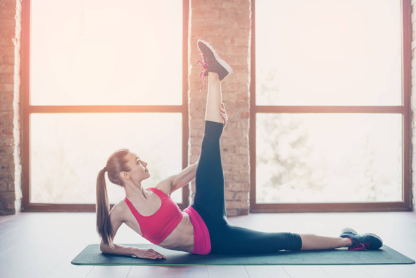 Young slim fit woman is doing stretching before start her traini - Photo, Image