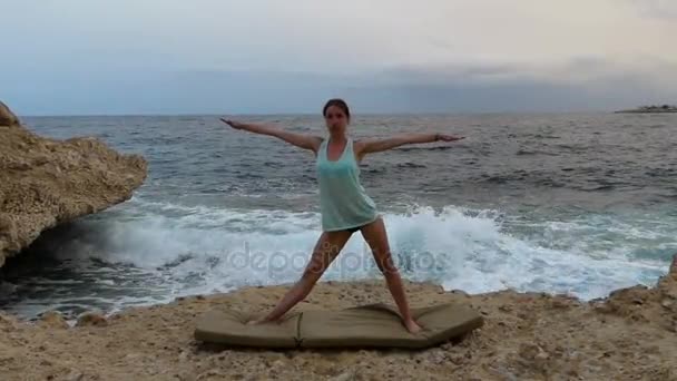 Fiatal nő csinálás háromszög jelentenek a jóga gyakorlása a Seabeach. - Felvétel, videó