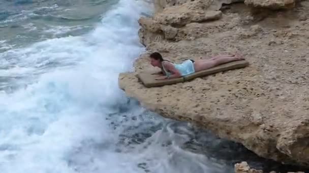 マーメイドのような美しい若い女性は石 Seabeach の Sunlounge に横たわる. - 映像、動画
