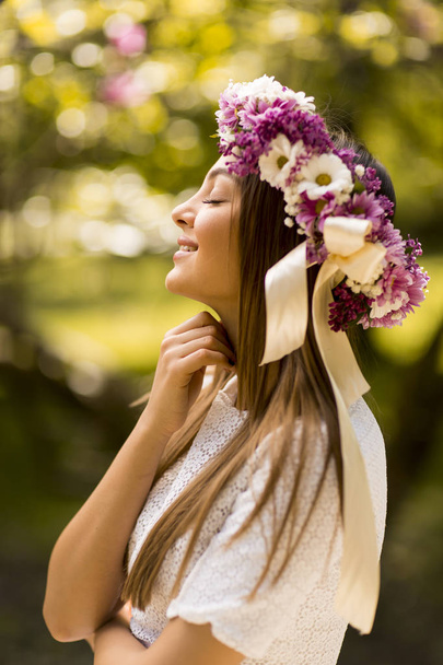 Young woman with flower wreath - Фото, зображення