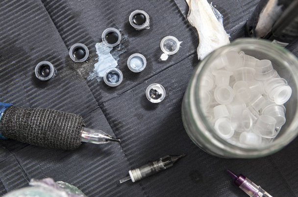 Tatuointi taiteilija pöytä useita mustetta pieniä kuppeja ja kynä muste mach
 - Valokuva, kuva