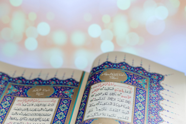 Otwieranie stron książki Święty Koran z tłem świateł - Zdjęcie, obraz