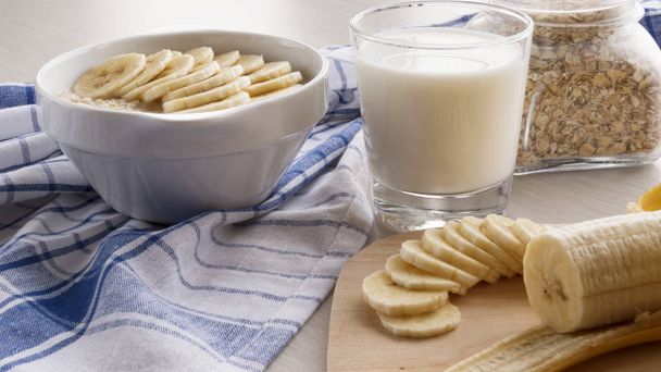 harina de avena con plátanos y un vaso de leche
 - Foto, Imagen