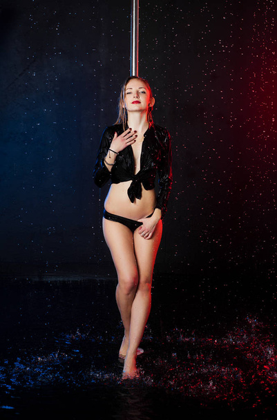 Uma jovem mulher europeia bonita em um estúdio de fotos com água está envolvida em meia-dança com abóbadas de pólo
 - Foto, Imagem