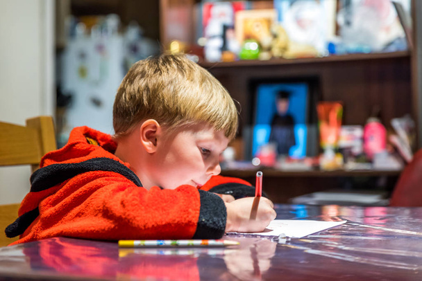 Dos chicos escribiendo una carta a Santa Claus en la mesa
 - Foto, Imagen