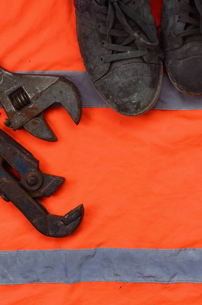 Rozváděcí a staré boty leží na oranžové signál worke - Fotografie, Obrázek