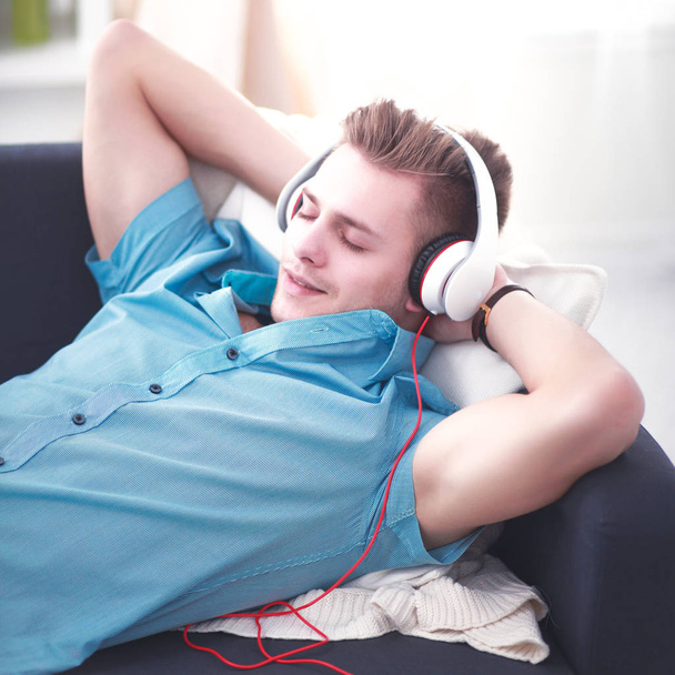 Man listening music with headphones at home - Fotó, kép