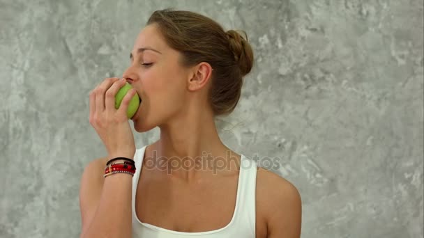 Eszik zöld alma, fiatal nő portréja - Felvétel, videó
