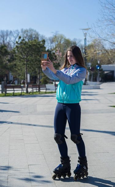 Roller Girl de pé e tiro selfie no smartphone
 - Foto, Imagem